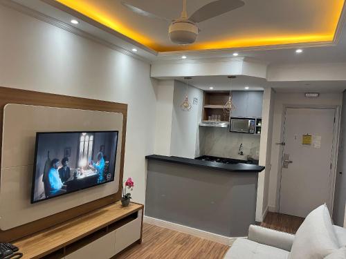 a living room with a flat screen tv on a wall at Flat Premium -Acesso a pé ao shopping Center vale - Edifício Summit (Ar condicionado) in São José dos Campos