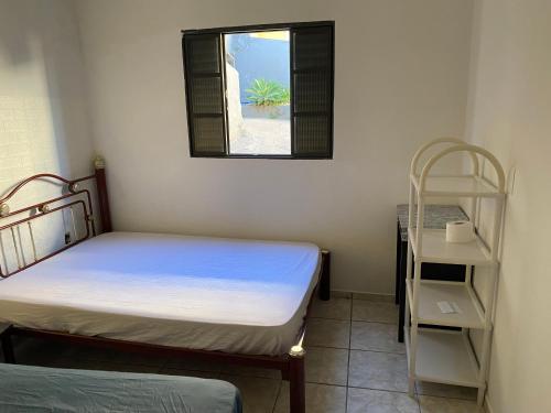 een kleine kamer met 2 bedden en een raam bij Casa in Águas de Lindóia
