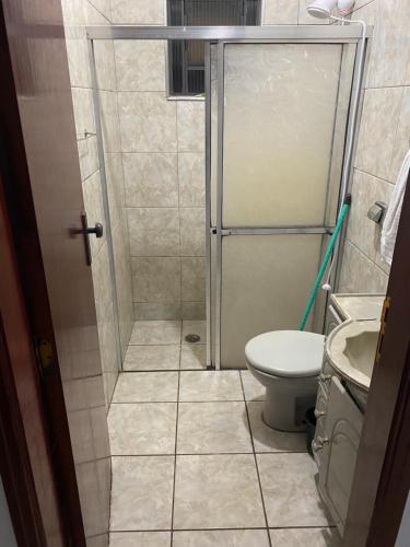 een badkamer met een douche, een toilet en een wastafel bij Casa in Águas de Lindóia