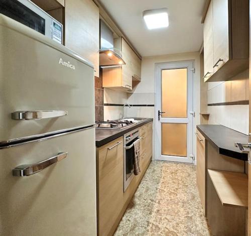 a kitchen with a refrigerator and a stove at Fabulous Fiery Flat w/ body shower - Tylorstown in Llwyn-y-pia