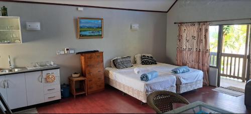 a bedroom with a bed with blue pillows on it at Shalini Garden Hotel & Apartments in Sigatoka