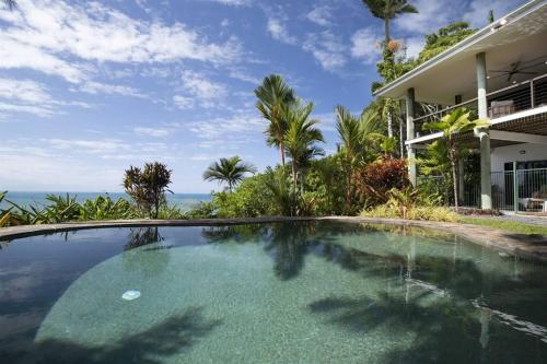 a swimming pool in front of a house at The Jungle House - 2 Bedroom Home - Bingil Bay in Mission Beach