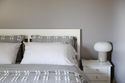 a bedroom with a white bed and a white lamp at Yucca Tree in Kelowna