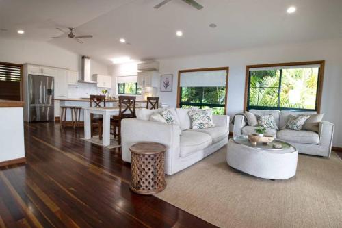 a living room with a couch and a table at The Jungle House - 2 Bedroom Home - Bingil Bay in Mission Beach