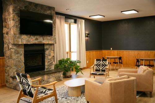 a living room with a fireplace and a tv at LOGE Wolf Creek in South Fork