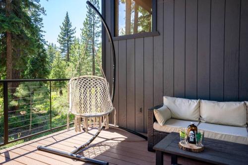 a porch with a wicker chair and a bench on a deck at Backs to Forest! Modern Lakehouse + Office, 5min to Kings Beach in Kings Beach