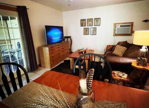 sala de estar con sofá y TV en The Hideaway at Bear Mountain Log Cabins en Eureka Springs