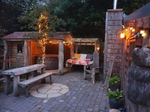eine Terrasse mit einem Tisch, einer Bank und einem Schuppen in der Unterkunft Charming 2-Bed Cabin in Sutton Coldfield in Sutton Coldfield
