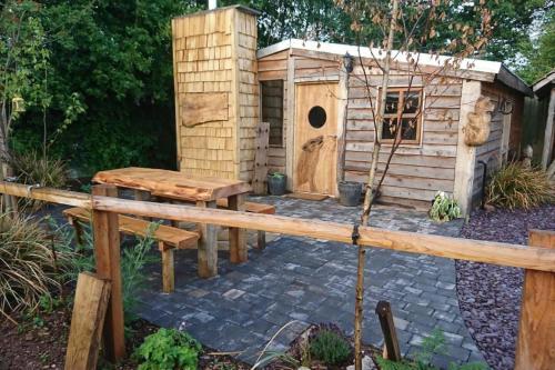 a dog house and a bench in a garden at Sutton Coldfield 2-Bed Caravan Parking & Bar-B-Q in Sutton Coldfield