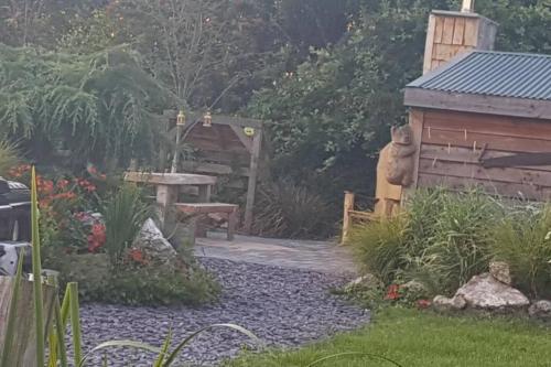 a garden with a bench and a table and a shed at Sutton Coldfield 2-Bed Caravan Parking & Bar-B-Q in Sutton Coldfield