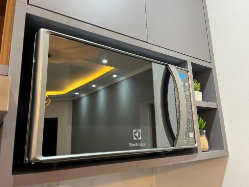 a microwave oven with a window in a kitchen at Flat Premium -Acesso a pé ao shopping Center vale - Edifício Summit (Ar condicionado) in São José dos Campos