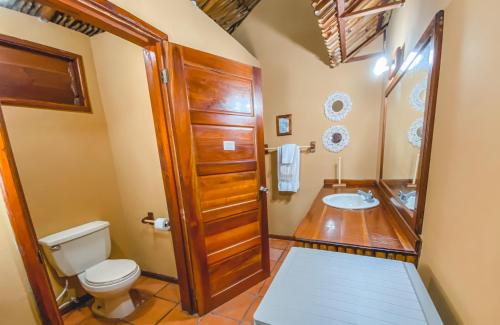 a bathroom with a toilet and a sink at The Mayan Garden in Orange Walk