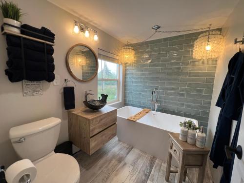 ein Badezimmer mit einer Badewanne, einem WC und einem Waschbecken in der Unterkunft Seaside Serenity Cottage in Shelburne