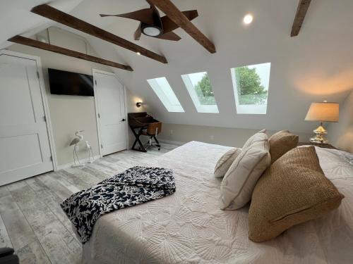 ein Schlafzimmer mit einem weißen Bett und einer Decke mit Fenstern in der Unterkunft Seaside Serenity Cottage in Shelburne