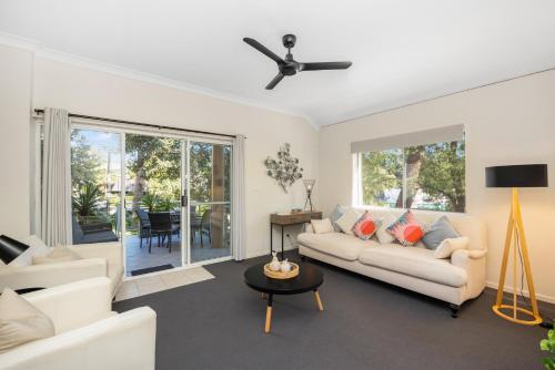 a living room with a couch and a ceiling fan at Enjoy 15 percent off stays in February and March, discount already applied to the nightly rate. Book now. in Mollymook