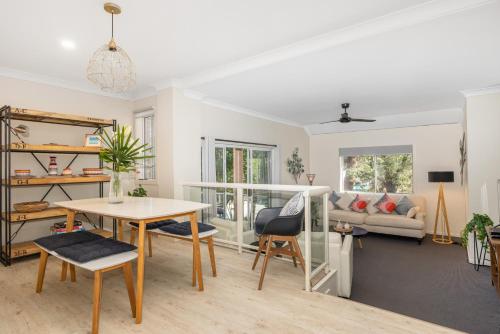a living room with a table and a couch at Enjoy 15 percent off stays in February and March, discount already applied to the nightly rate. Book now. in Mollymook