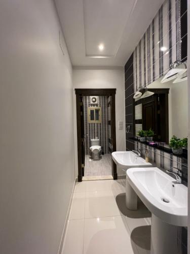 a bathroom with two sinks and a toilet at Loft 16 in Jeddah