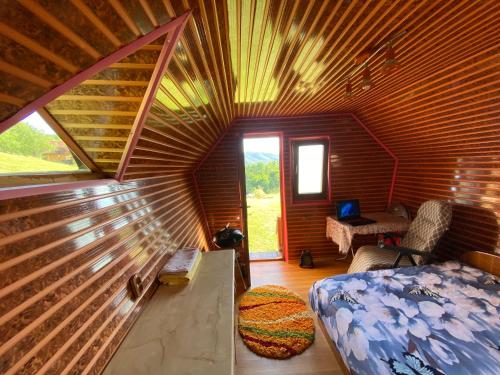 um quarto com uma cama e um tecto de madeira em Căbănuță rustică 02 em Băniţa