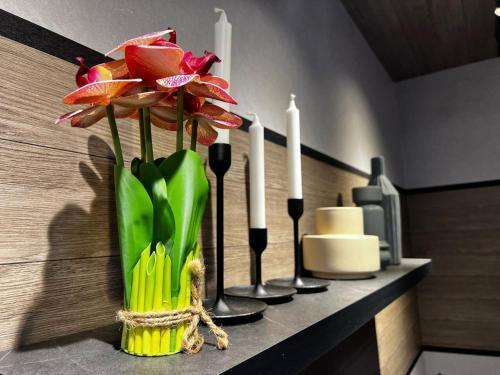 a vase with flowers on a counter with candles at Topaz Nilam Residence 5 pax The Shore KK Centre in Kota Kinabalu
