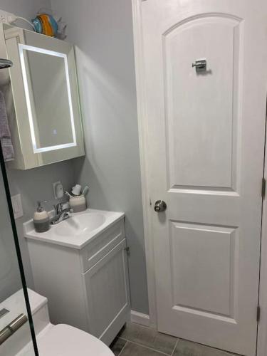 a bathroom with a white toilet and a sink at River Run Cottage Modern 2BR Waterfront Retreat in Linville Land Harbor in Newland