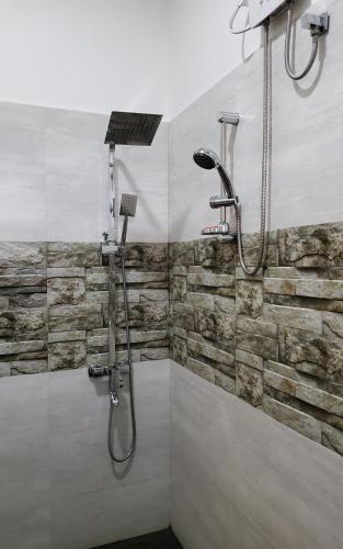 a bathroom with a shower with a stone wall at Thimaya Resort in Hatton