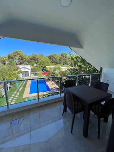 a balcony with a table and chairs and a pool at Sea Life Homes in Kemer