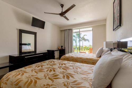 - une chambre avec 2 lits et une grande fenêtre dans l'établissement Brisa Color Esmeralda, à Brisas de Zicatela