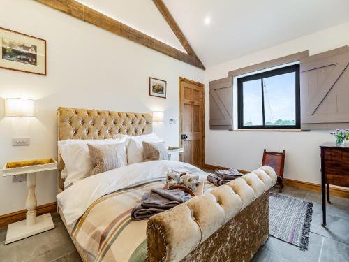 - une chambre avec un grand lit et une fenêtre dans l'établissement Loch Farm Stables, à Watton