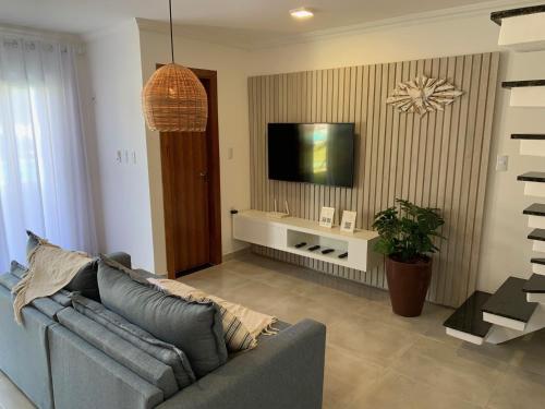 un soggiorno con divano e TV a schermo piatto di Casa incrível em condomínio - Arraial d'Ajuda a Arraial d'Ajuda