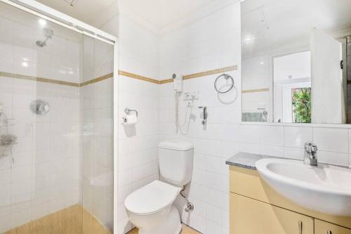 a white bathroom with a toilet and a sink at Modern comfort Chippen119 Self Catering in Sydney