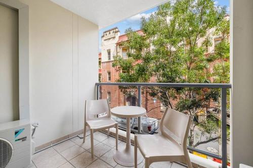 a balcony with a table and chairs and a window at Modern comfort Chippen119 Self Catering in Sydney