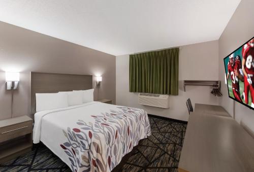 um quarto de hotel com uma cama e uma janela em Red Roof Inn Mansfield em Mansfield