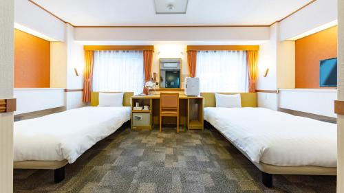 Pokój szpitalny z 2 łóżkami i biurkiem w obiekcie Toyoko Inn Tokyo Shinagawa Hatanodai eki Minami guchi w Tokio