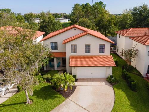 a white house with an orange roof at Affordable 4 Br Luxury Villa near Disney/Private Pool/Arcade/Game room in Orlando