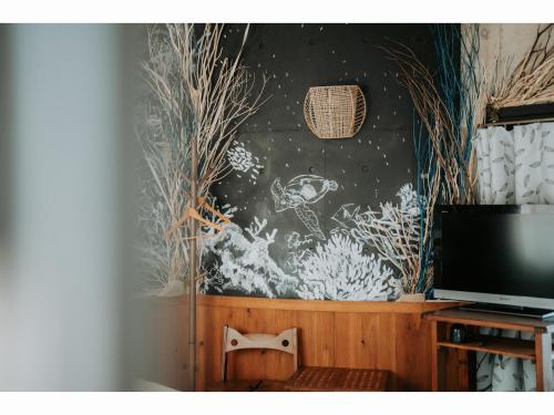 a room with a television and a wall mural at Buzz Resort in Onna