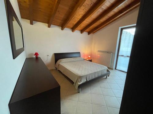 um quarto com uma cama e uma grande janela em Villetta 2 piani em Borgo Ticino