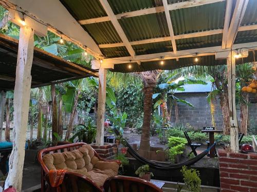 eine Terrasse mit Hängematte in einem Garten mit Bäumen in der Unterkunft Casa Esmeralda in Moyogalpa