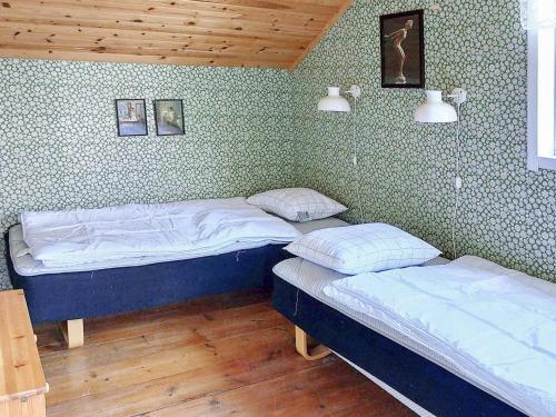 two twin beds in a room with green walls at Holiday home Husum in Husum