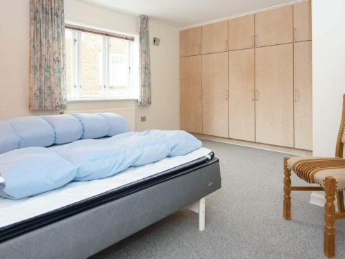 ein Schlafzimmer mit einem Bett mit blauen Kissen darauf in der Unterkunft Holiday home Højer III in Højer