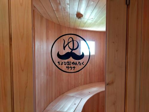 a sign on a wooden wall in a sauna at Buzz Resort in Onna