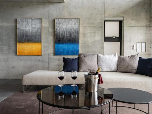 a living room with a couch and two wine glasses on a table at K-Style-Resort-SEVEN Hotels and Resorts- in Nakijin