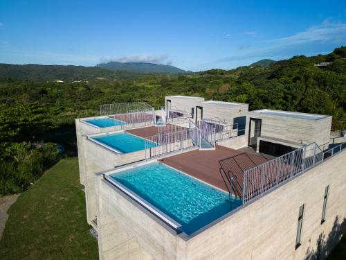 an aerial view of a house with two swimming pools at K-Style-Resort-SEVEN Hotels and Resorts- in Nakijin