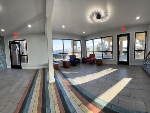 a lobby with a waiting area with chairs and windows at Motel 6 Soledad, CA in Soledad