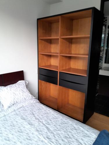 a bedroom with a large wooden bookcase next to a bed at Aparta Suite La Candelaria in Bogotá