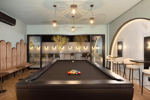 a billiard room with a pool table and chairs at I Am Design Hotel Itapema by Hotelaria Brasil in Itapema