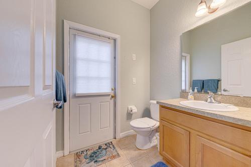 a bathroom with a toilet and a sink and a window at Affordable 4 Br Luxury Villa near Disney/Private Pool/Arcade/Game room in Orlando