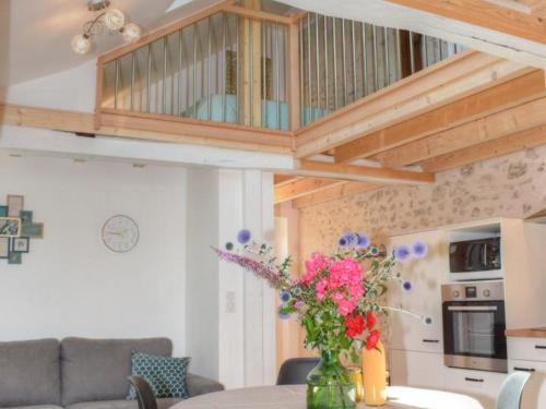 un salon avec une table avec un vase de fleurs dans l'établissement Gîte tout inclus à Joué-lès-Tours avec grand jardin, proche châteaux et nature - FR-1-381-545, à Joué-lès-Tours