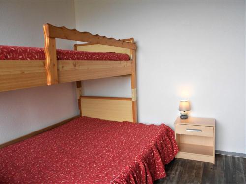 une chambre avec un lit superposé avec un couvre-lit rouge dans l'établissement Appartement lumineux · Pied des pistes · Double balcon · WIFI gratuit · Piscine incluse - FR-1-267-253, à Villarembert