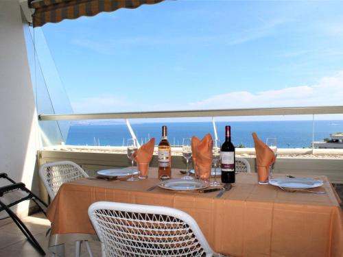 - une table avec des bouteilles de vin assises sur un balcon dans l'établissement Appartement 2 Pièces, 4 couchages avec terrasse et vue panoramique - FR-1-252A-112, à Villeneuve-Loubet