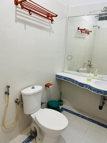 a bathroom with a toilet and a sink and a mirror at Chameleon Beach Resort, Cherai in Cochin